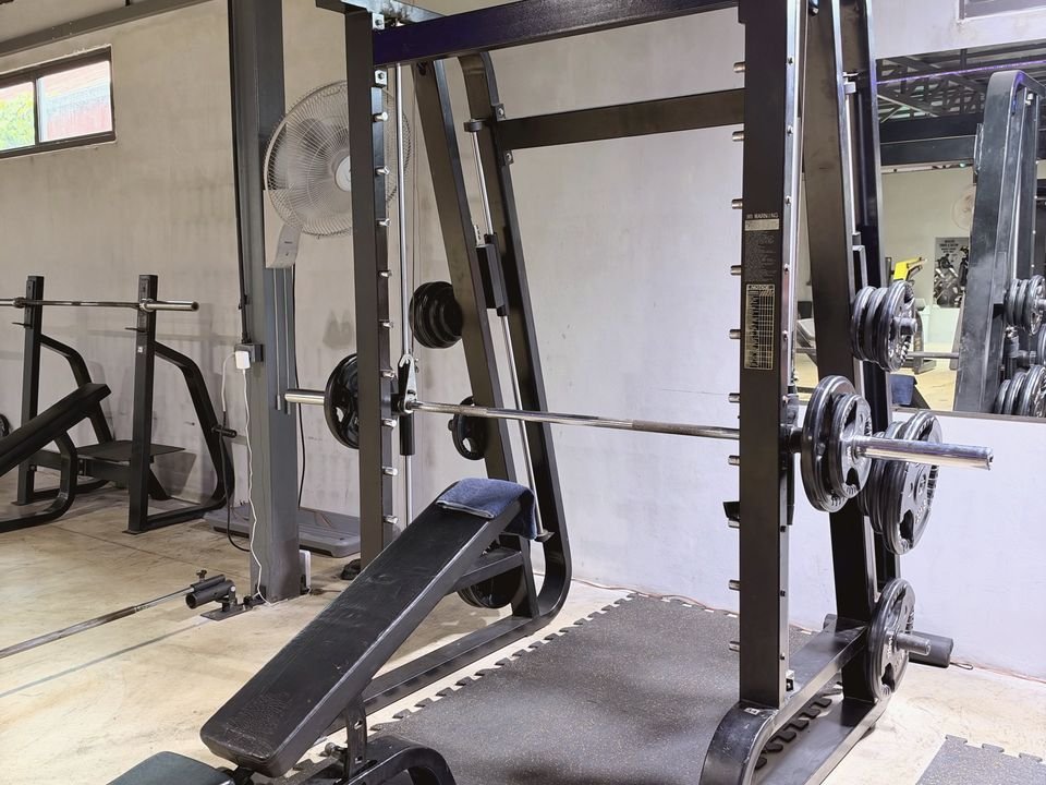 Smith machine with an adjustable bench and weight plates