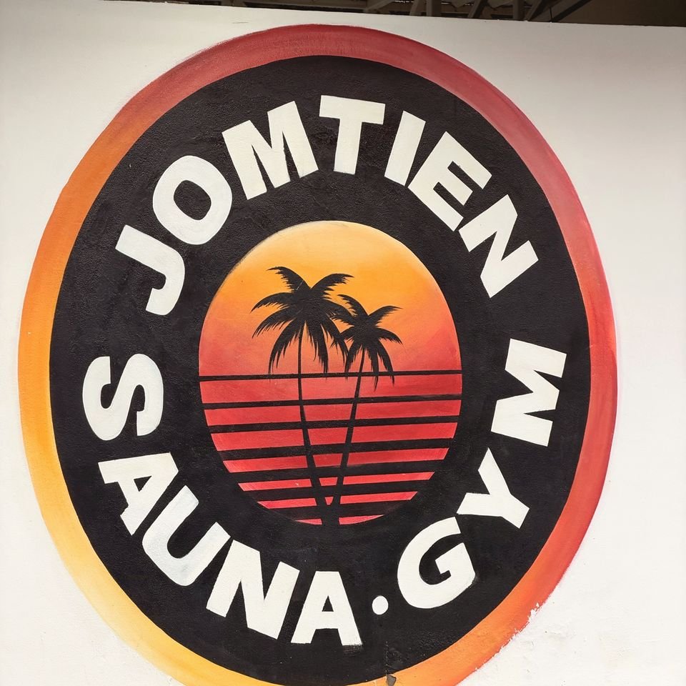 Painted Jomtien Sauna & Gym logo, palm trees on a sunset, on a white wall by the pool
