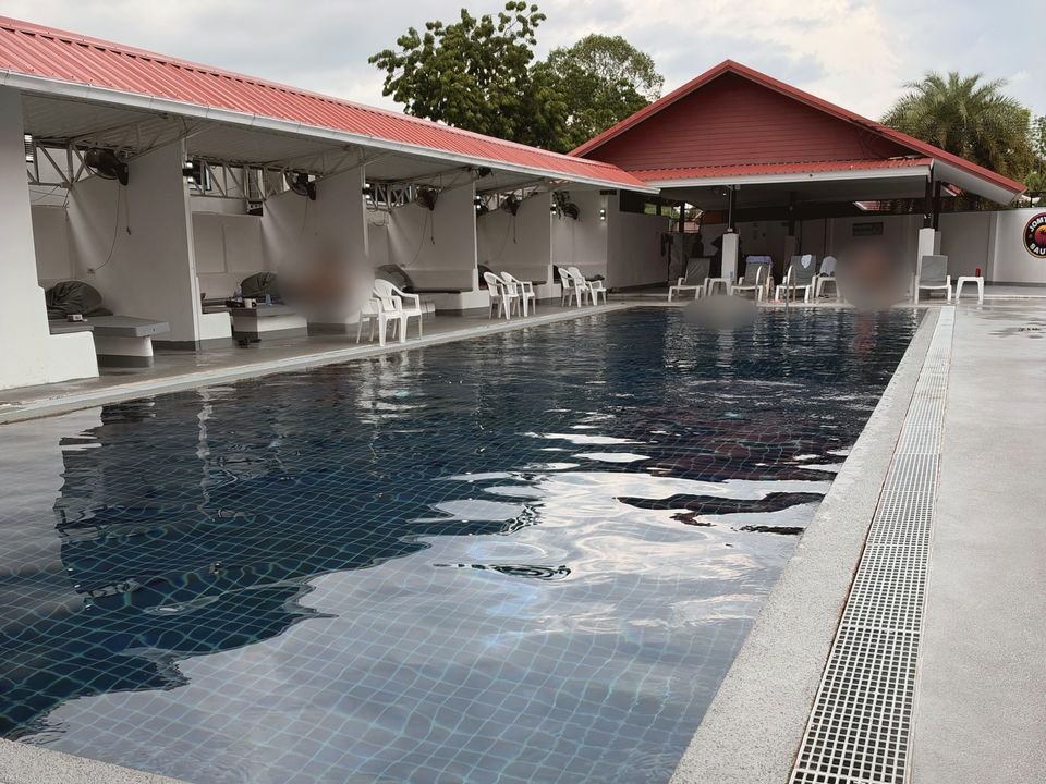 Открытый бассейн, лежаки и беседки под красной крышей в Jomtien Sauna & Gym, Паттайя