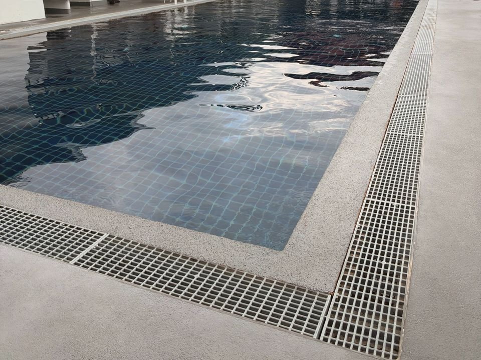 Clear water and the grated overflow edge of the outdoor pool